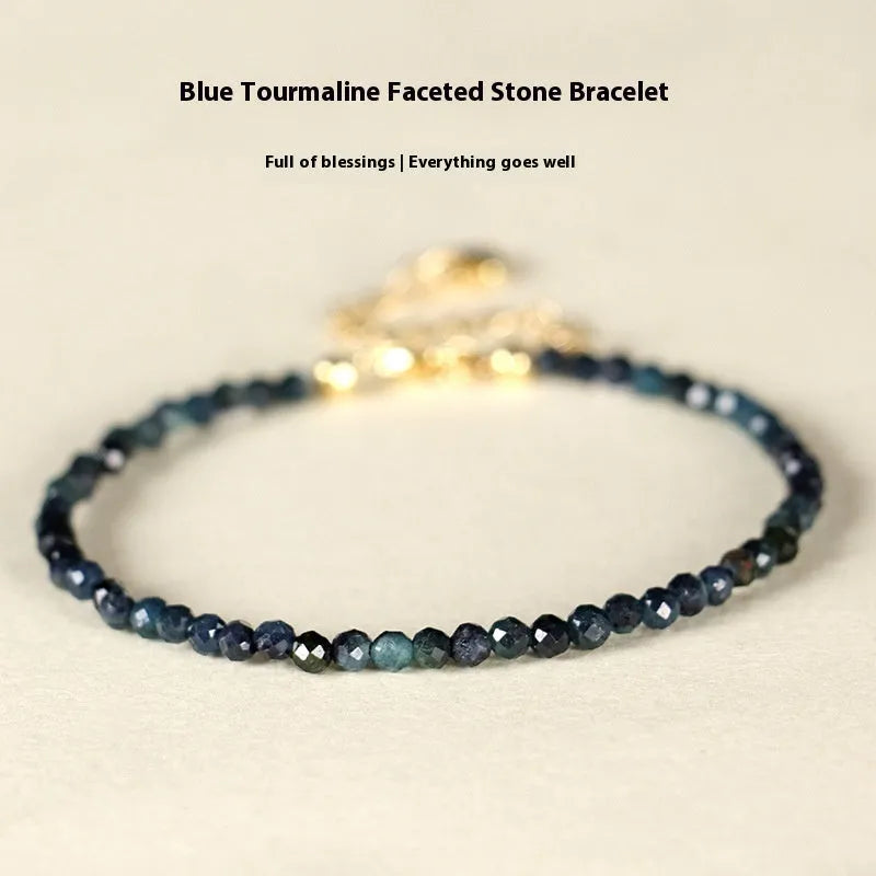 Close-up of a women's blue tourmaline beaded bracelet with 3mm beads and spacer sections.