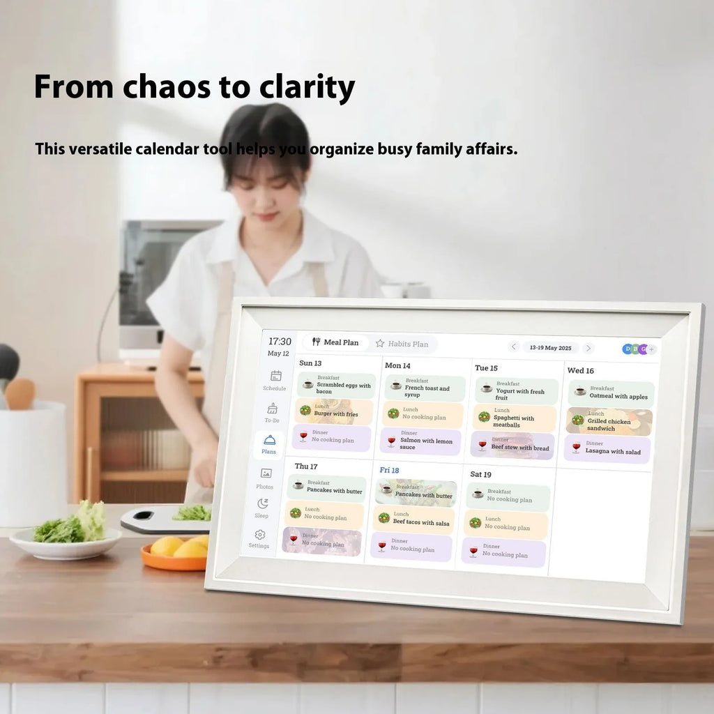 White smart digital photo frame with 15.6 inch screen on a table, showing family photos.