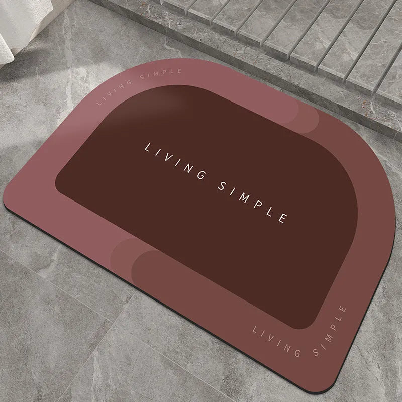 Grey oval super absorbent polyester bath mat with non-slip rubber bottom on tiled floor