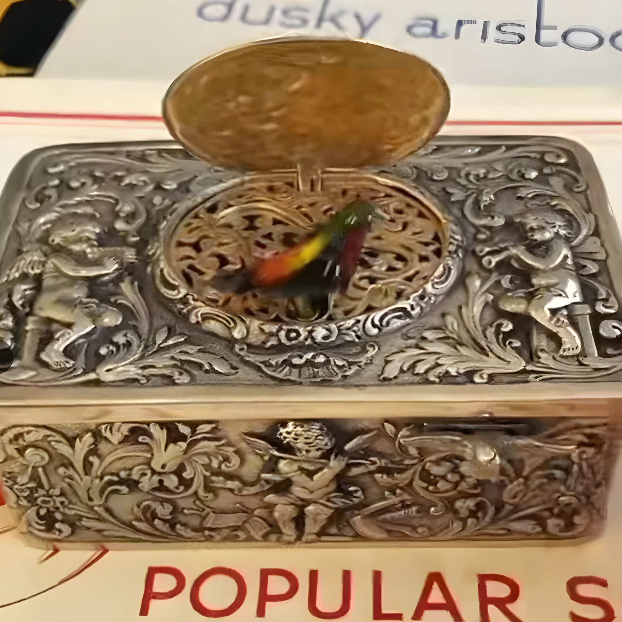 Gold alloy automatic pop-up bird box decoration on a tabletop, 10x6x4 cm