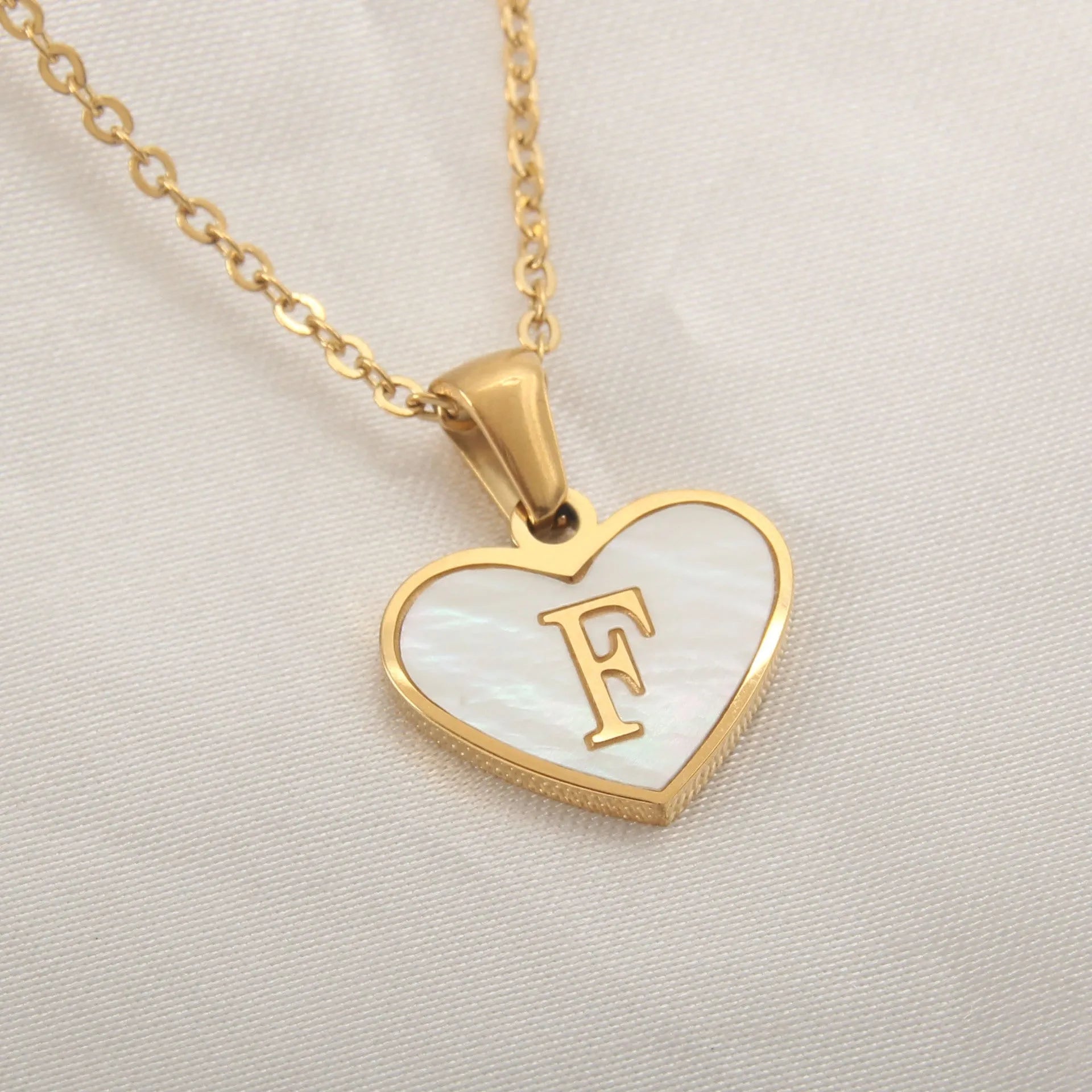 Gold heart necklace with white shell detail and personalised initial letter on adjustable chain