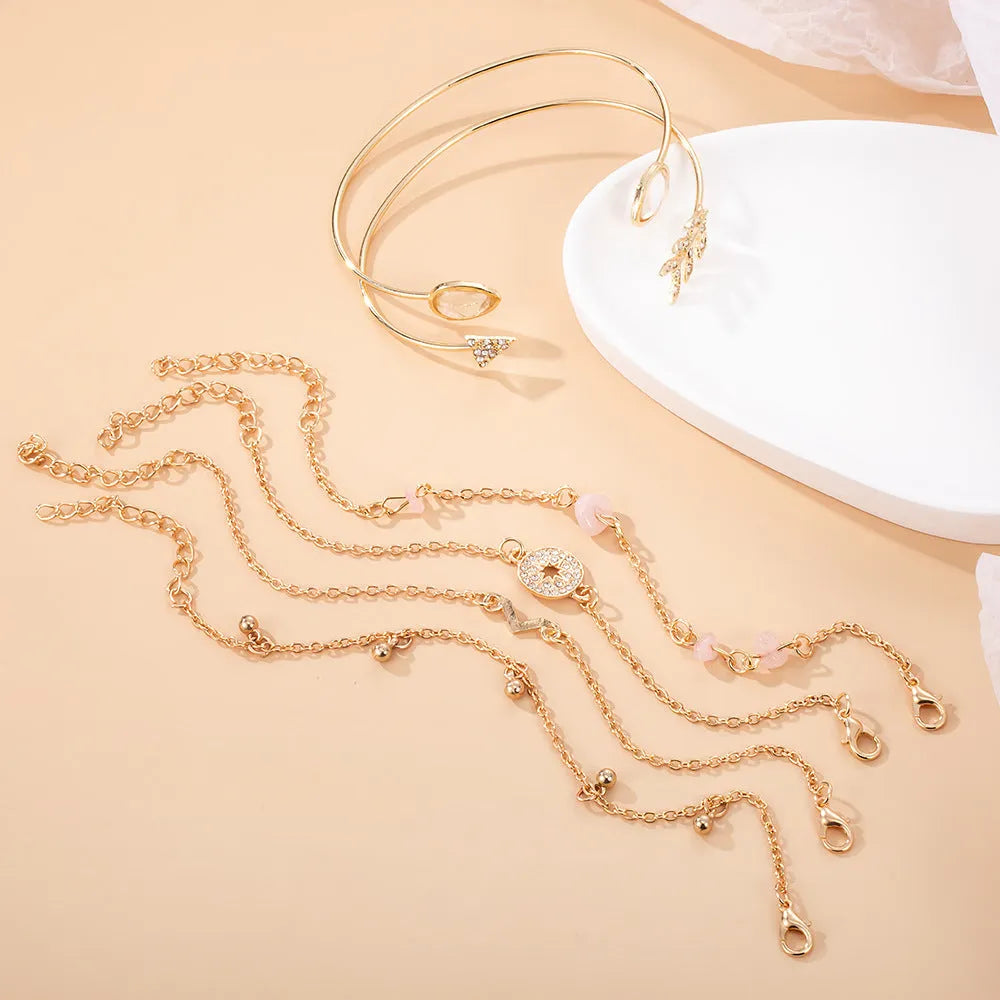 Golden bracelet charm set with six pieces including V-shape, arrow, water drop and drill spot designs