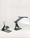 Black foldable mobile phone screen magnifier with detachable phone holder on a desk