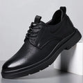 Men's black and brown leather casual sneakers with rubber sole and sewing line detail on the upper.