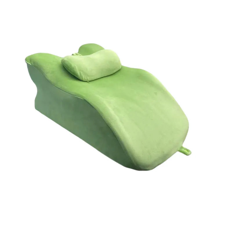A stomach sleeper pillow shown in light grey, designed for reading or phone use in a prone position.
