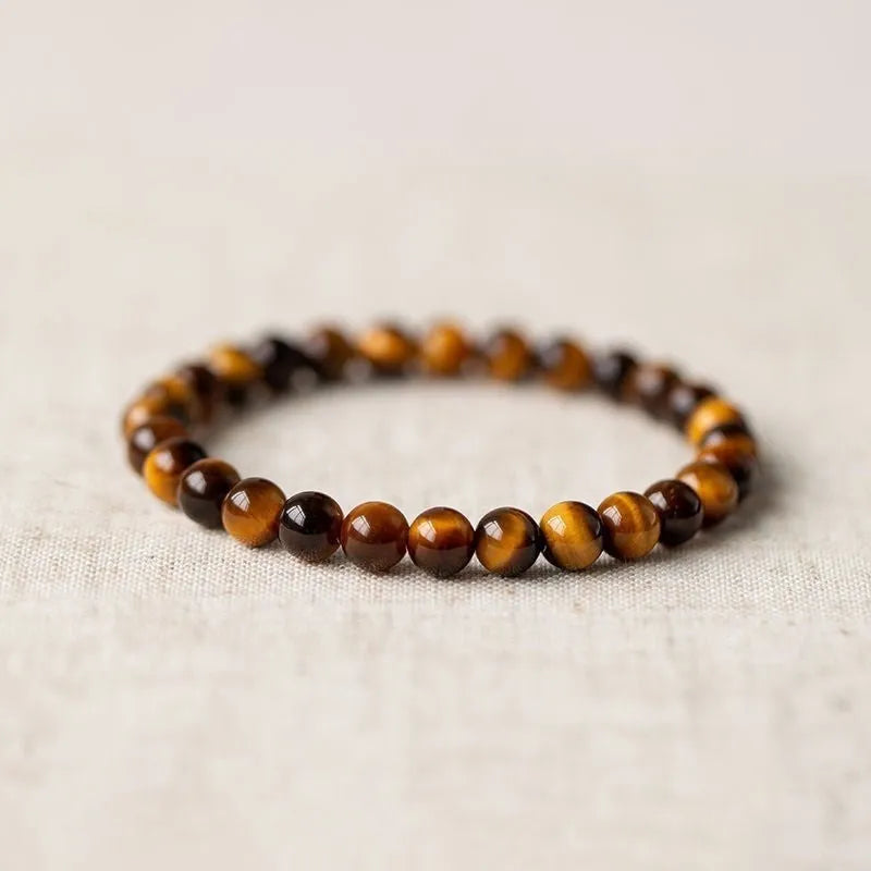 Tigereye Dzi bead single circle Buddha rosary bracelet on a wrist.