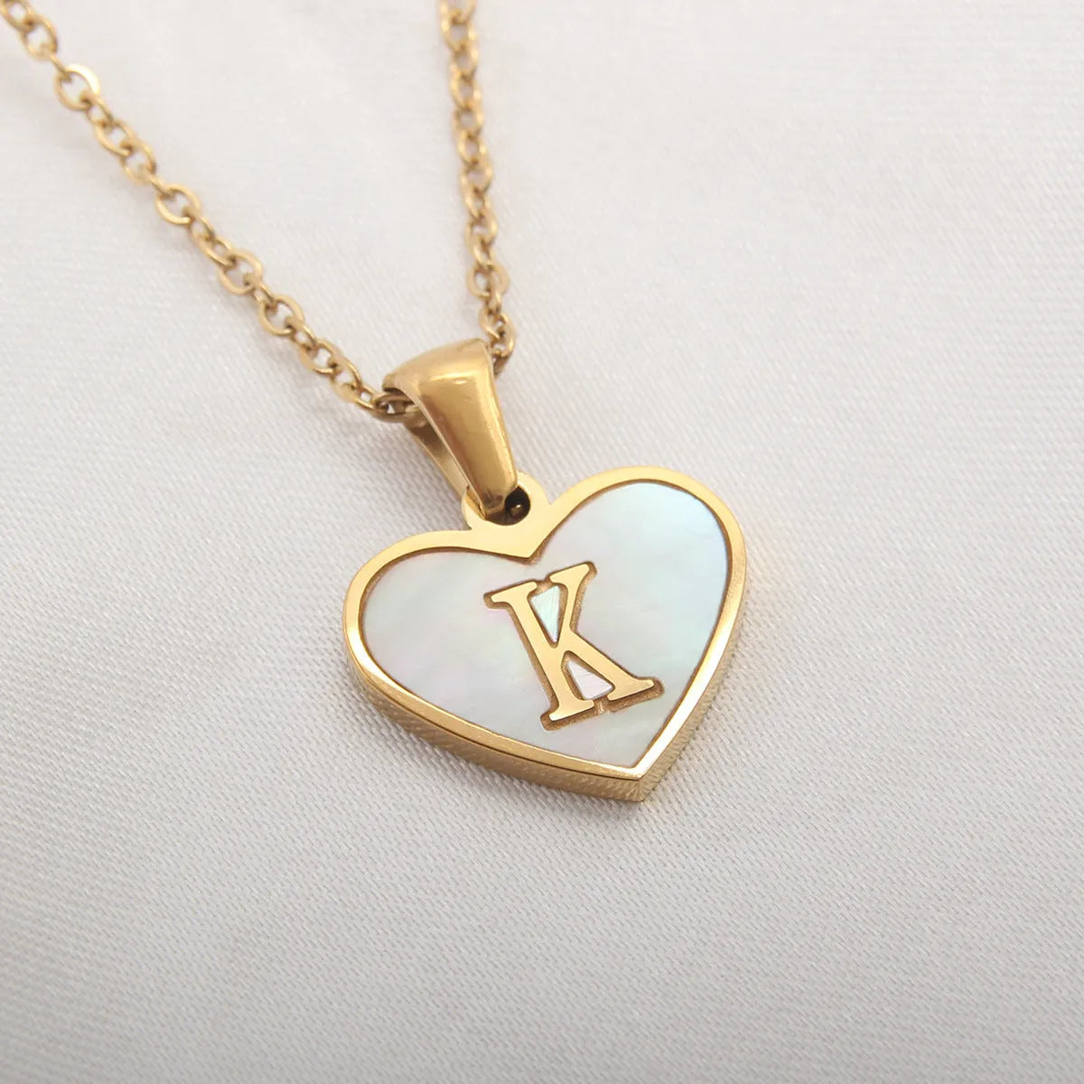Gold heart necklace with white shell detail and personalised initial letter on adjustable chain