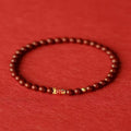 Natural cinnabar koi carp bracelet with gold ball in 4mm or 6mm size on wrist.