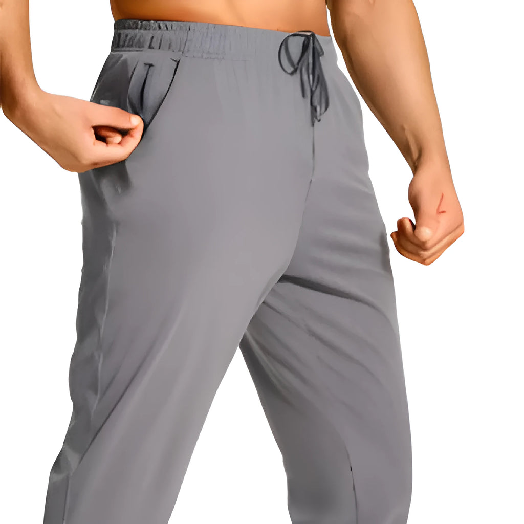 Men's loose-fitting casual polyester trousers in a solid colour on a hanger.