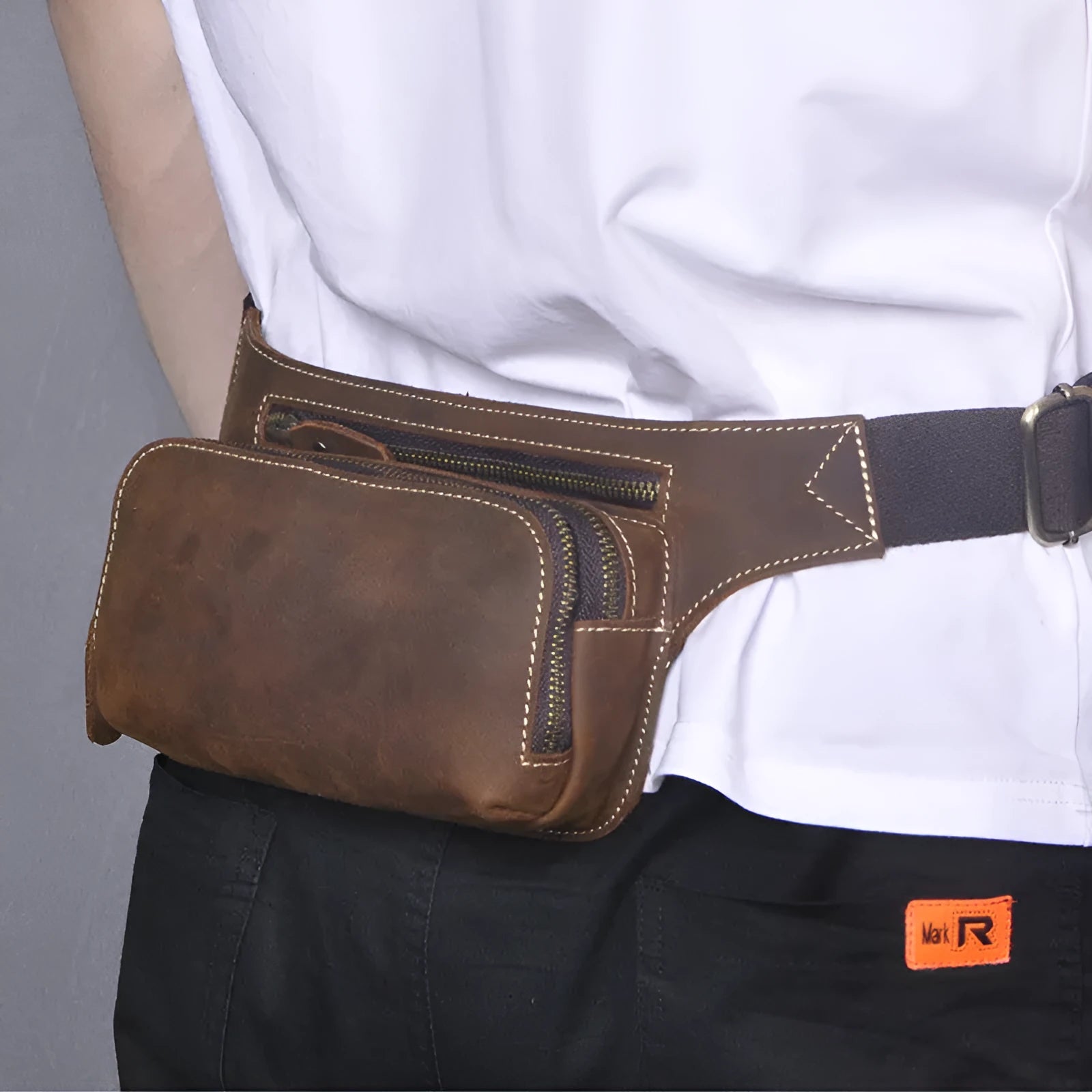 Brown top layer cowhide men's sports waist bag showing pull closure and internal mobile phone pocket