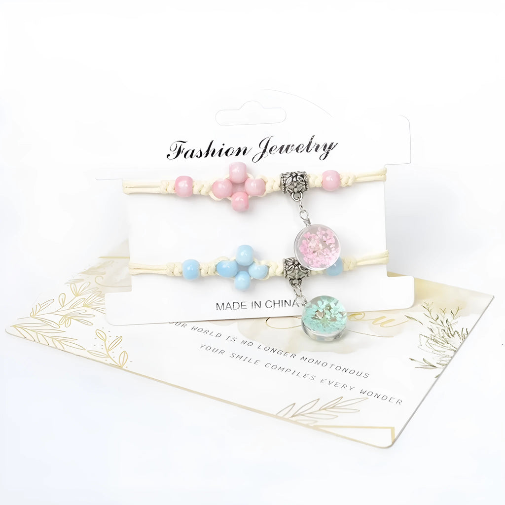 Glass bracelet with large colourful beads containing real dried flowers, on a white background.