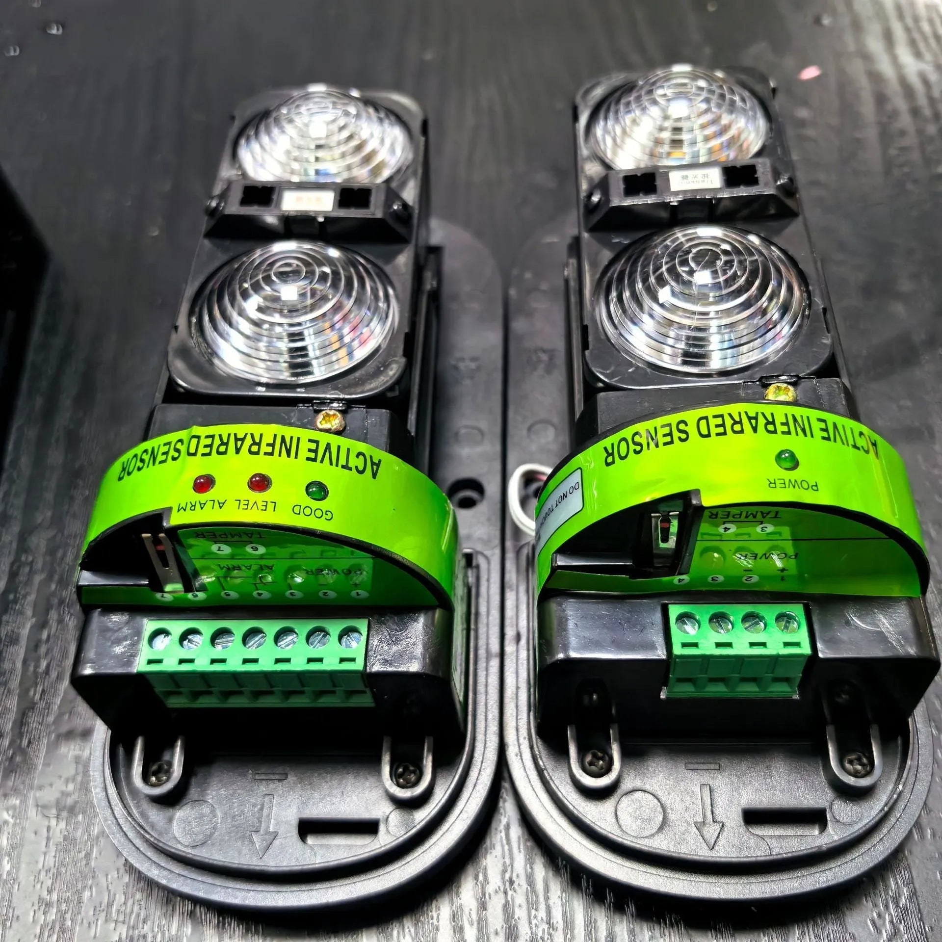 A pair of black wired infrared security detectors for 150-metre perimeter alarm systems.