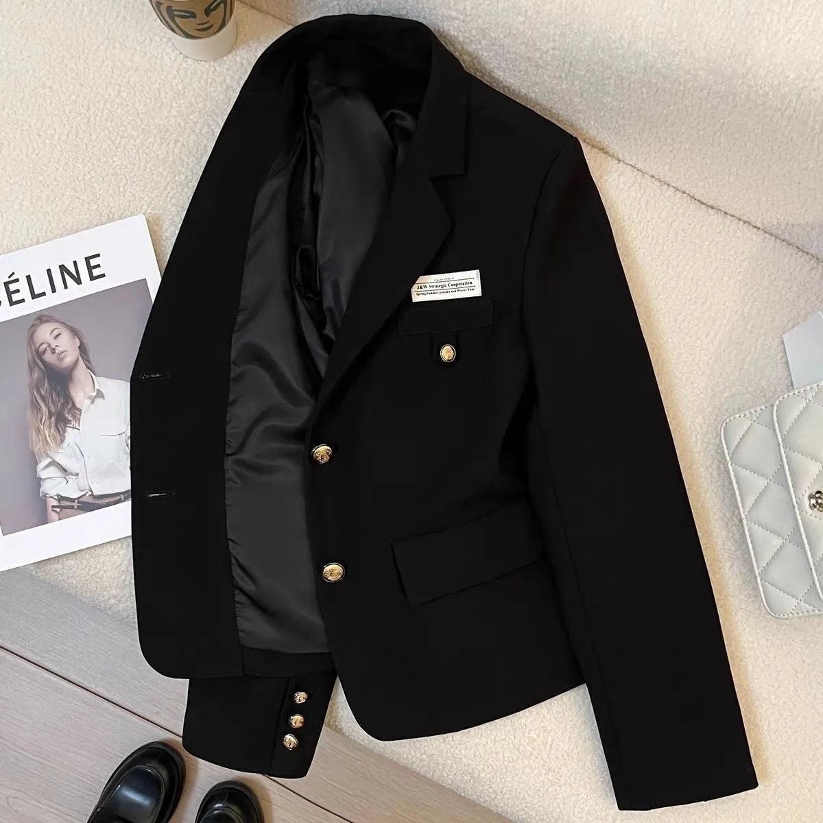 Black women's loose-fit short coat jacket with pockets and regular long sleeves.