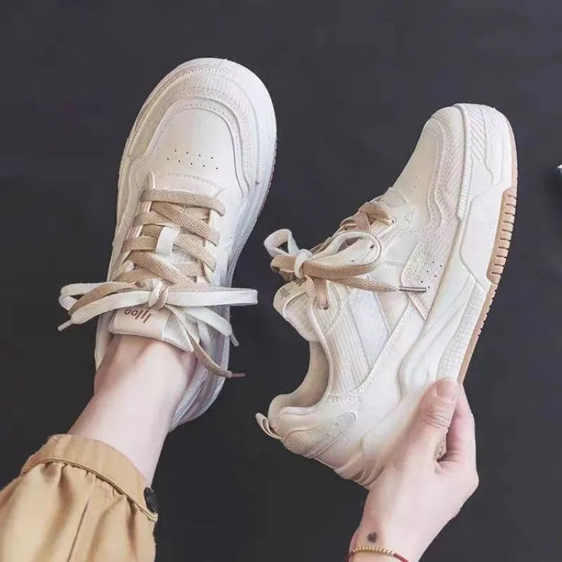 Pink and beige low-top sneakers with a rubber sole and imitation leather upper.