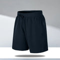 Man wearing loose fit black quick-dry sports shorts on a beach.