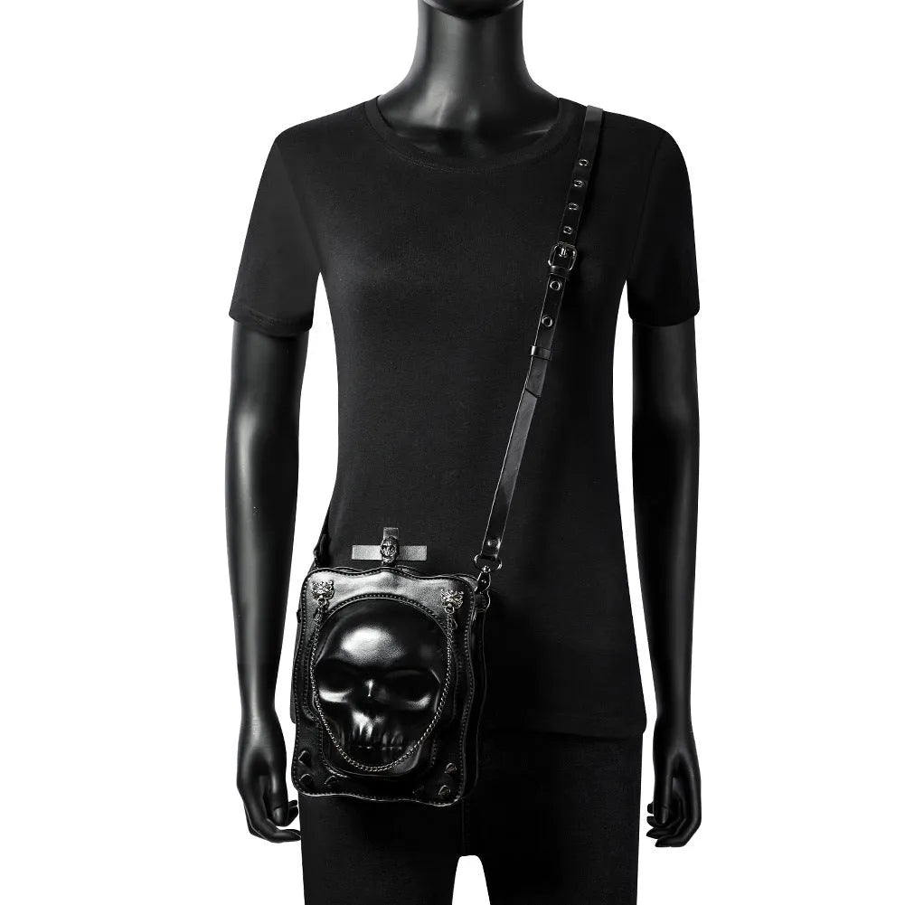 Black Gothic skull crossbody bag with square shape, chain detail, and zipper opening