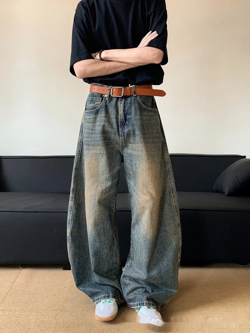 Men's retro blue distressed denim pants with a slim wide-leg fit and a zipper fly.