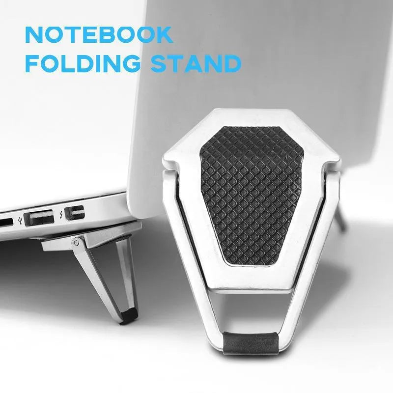 Compact silver aluminium folding laptop stand on a desk next to a wireless keyboard.