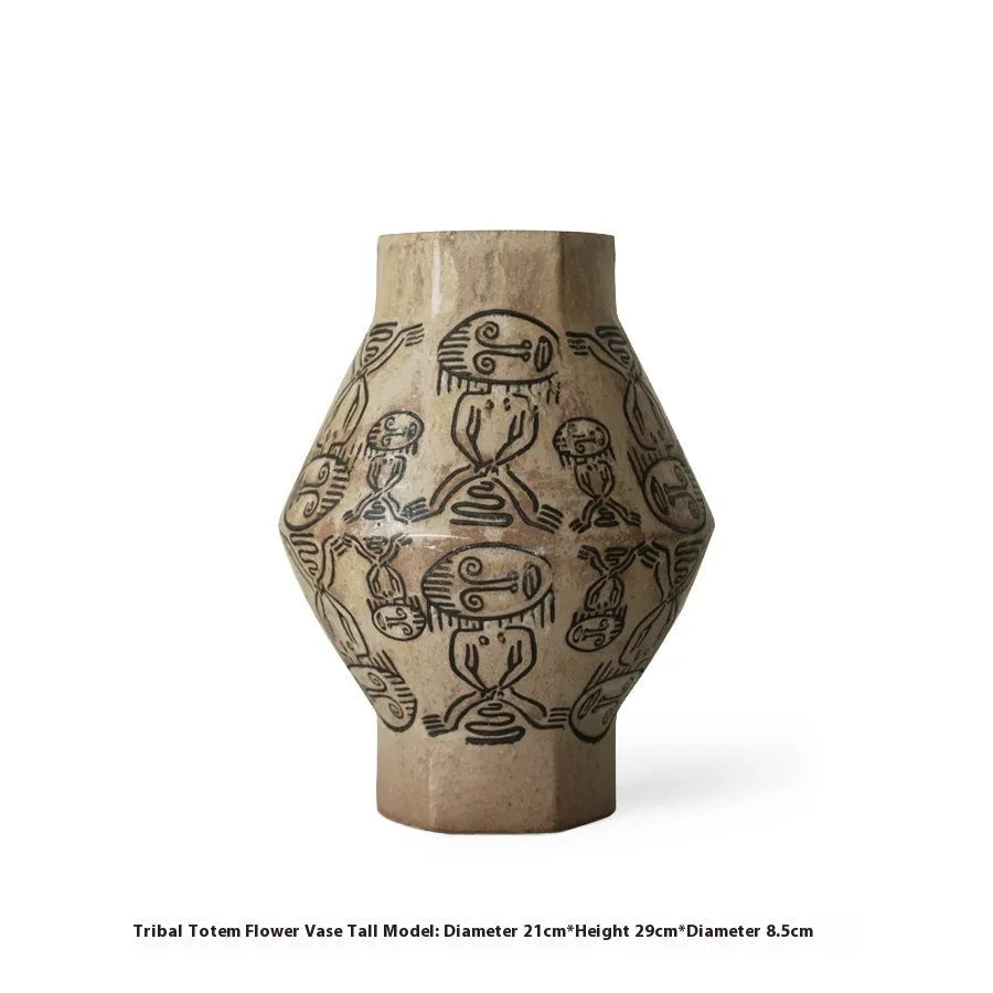 Hand-painted ceramic vase with carved tribal totem art in cylindrical shape.
