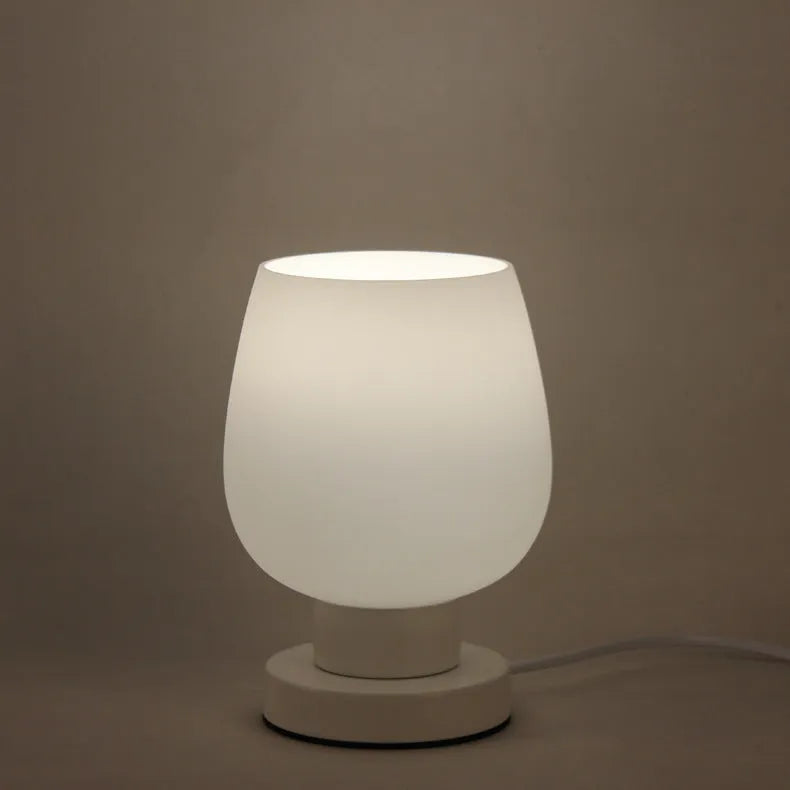 Nordic touch glass desk lamp with three colour settings and USB port on bedside table
