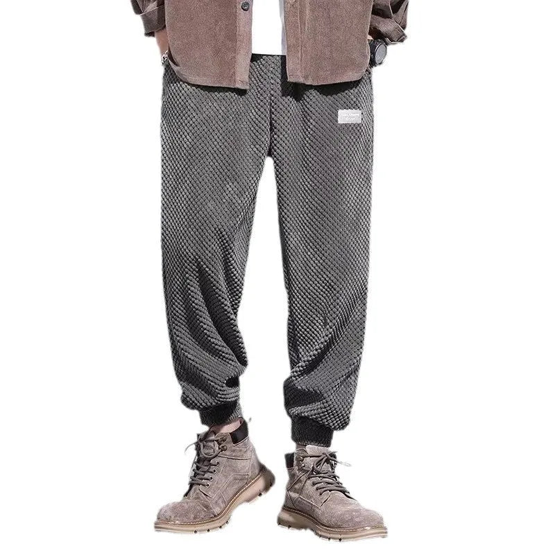 Men's grey ankle-tied straight leg sweatpants with elastic waist on a white background.