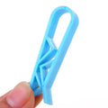 White PP plastic garbage bag fixing clip holding a black bin liner to a trash can rim.