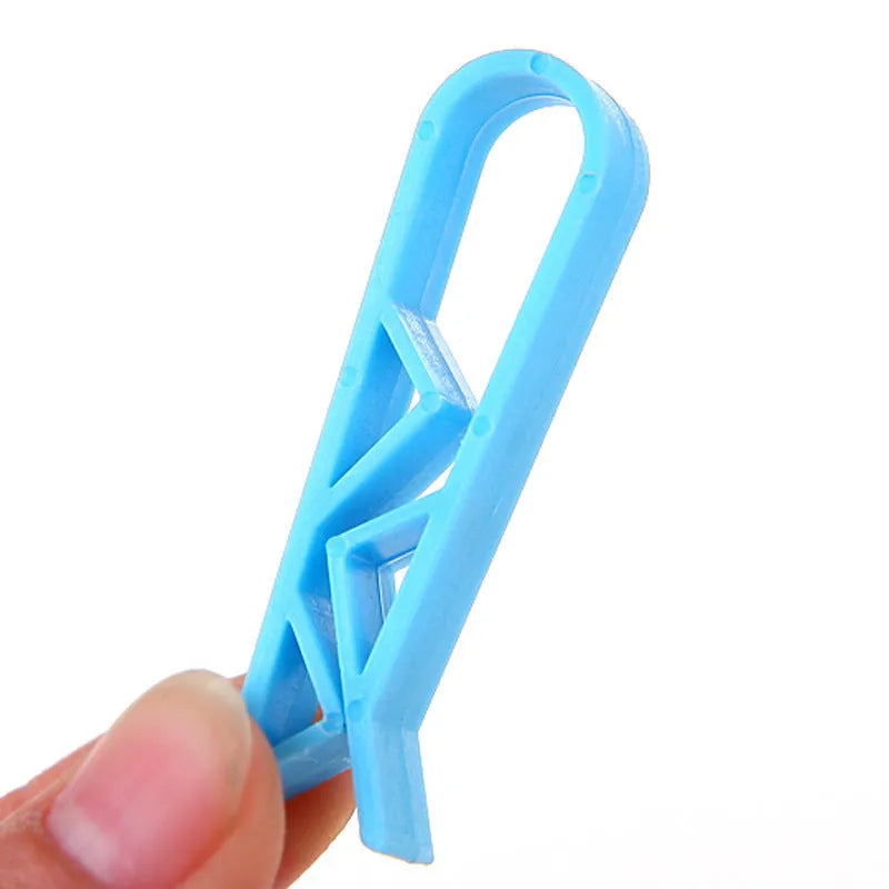 White PP plastic garbage bag fixing clip holding a black bin liner to a trash can rim.