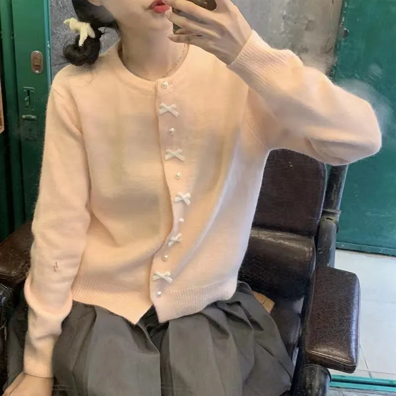Women's cashmere cardigan sweater with bow and pearl buttons across chest in light blue colour