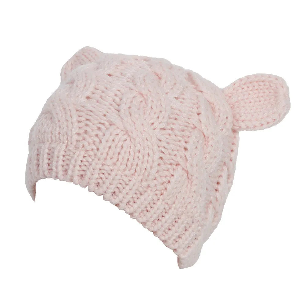 Handmade red knitted beanie with 3D cat ears on a white background