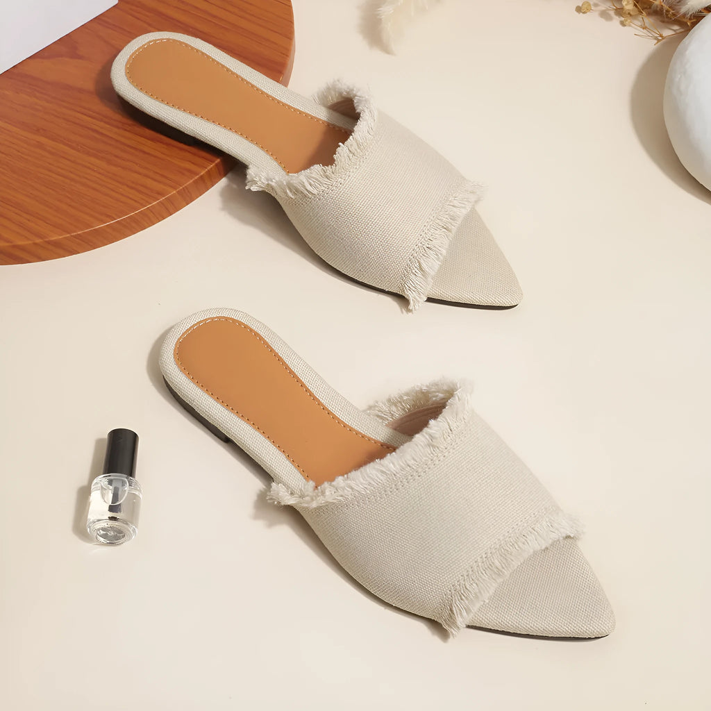 Women's casual denim flat slippers with leather lining and tassel detail.