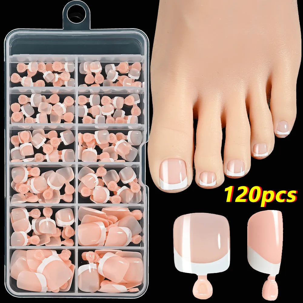 Box of 120 French white edge nude false toe nail pieces in assorted shades on a table