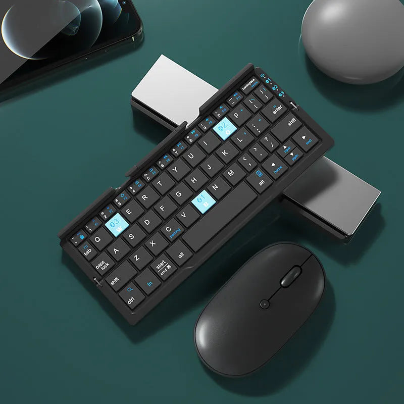 Silver white folding Bluetooth keyboard open next to a smartphone on its built-in metal stand.