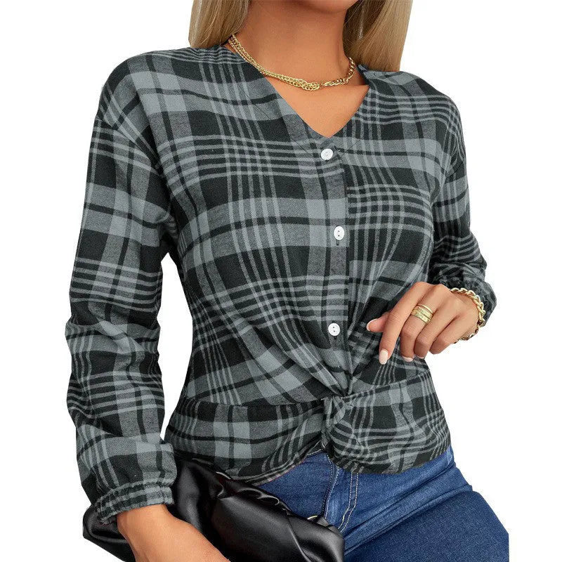 A woman wearing a loose-fitting purple plaid casual shirt with regular sleeves.