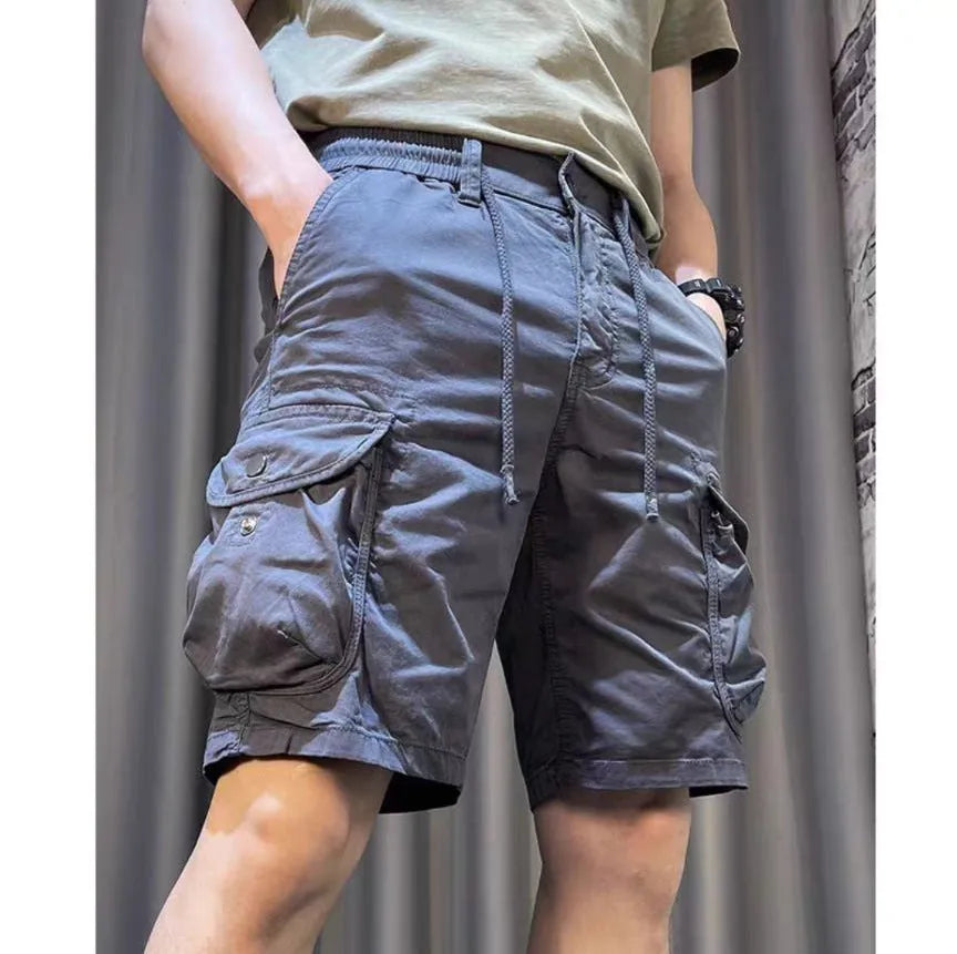 A model wearing loose straight-leg multi-pocket overalls in a khaki colour.