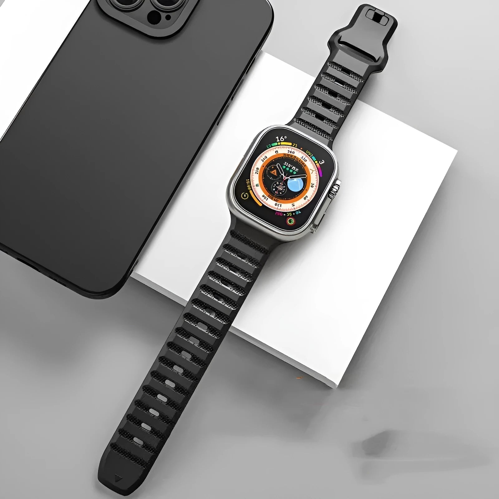 Fluoro rubber Apple Watch replacement band in multiple colours with T buckle, shown next to an Apple Watch.