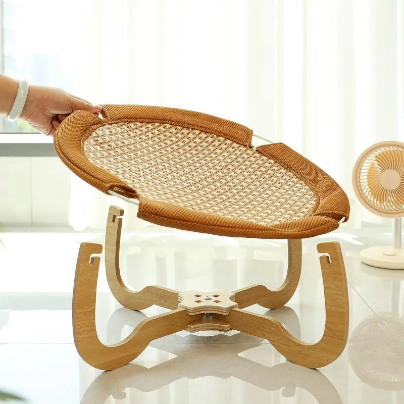 Brown square woven rattan pet hammock bed for cats and small dogs on a wooden floor.