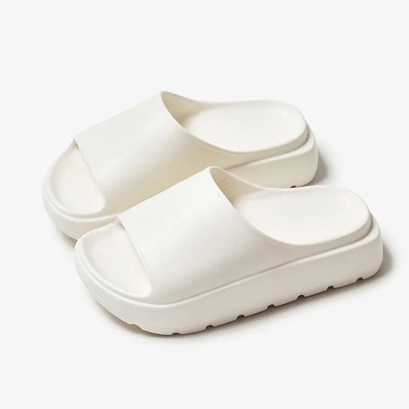 Women's beige thick soled EVA beach slippers with fish mouth design on a wooden floor