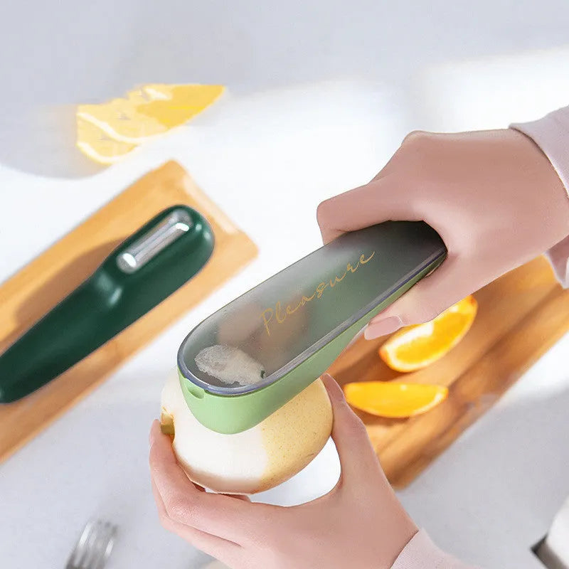 Dark green kitchen peeler with storage tube showing stainless steel blade and hangable handle