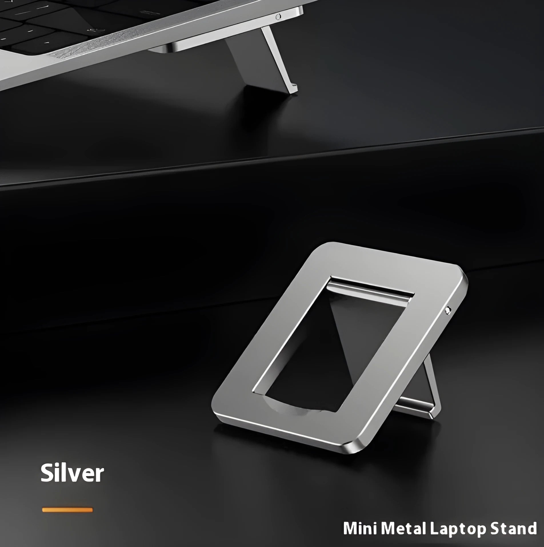 Compact silver aluminium folding laptop stand on a desk next to a wireless keyboard.
