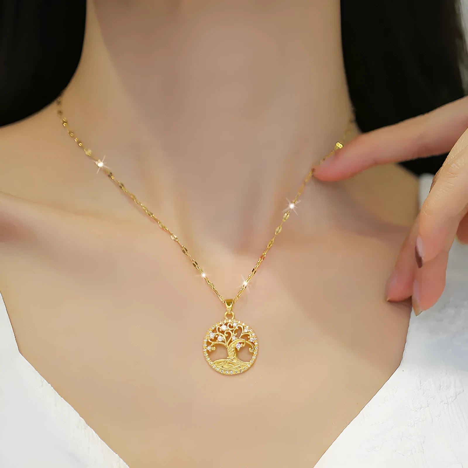 Gold-plated cross necklace with mother-of-pearl lucky tree pendant and rhinestone detailing on adjustable lip chain