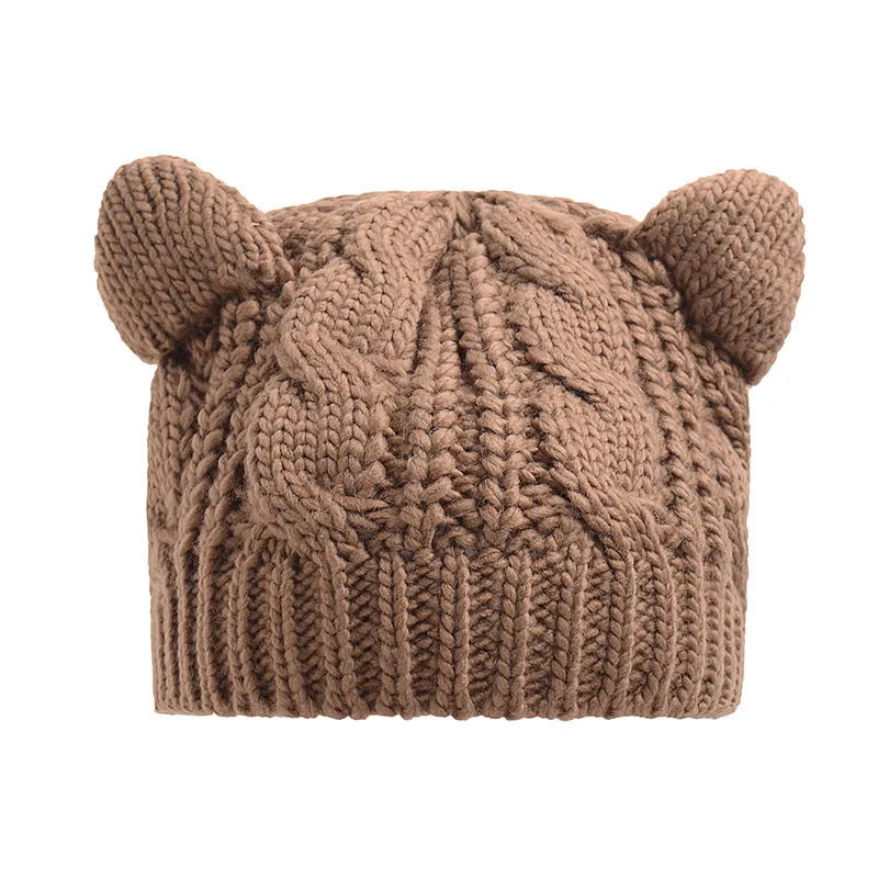 Handmade red knitted beanie with 3D cat ears on a white background