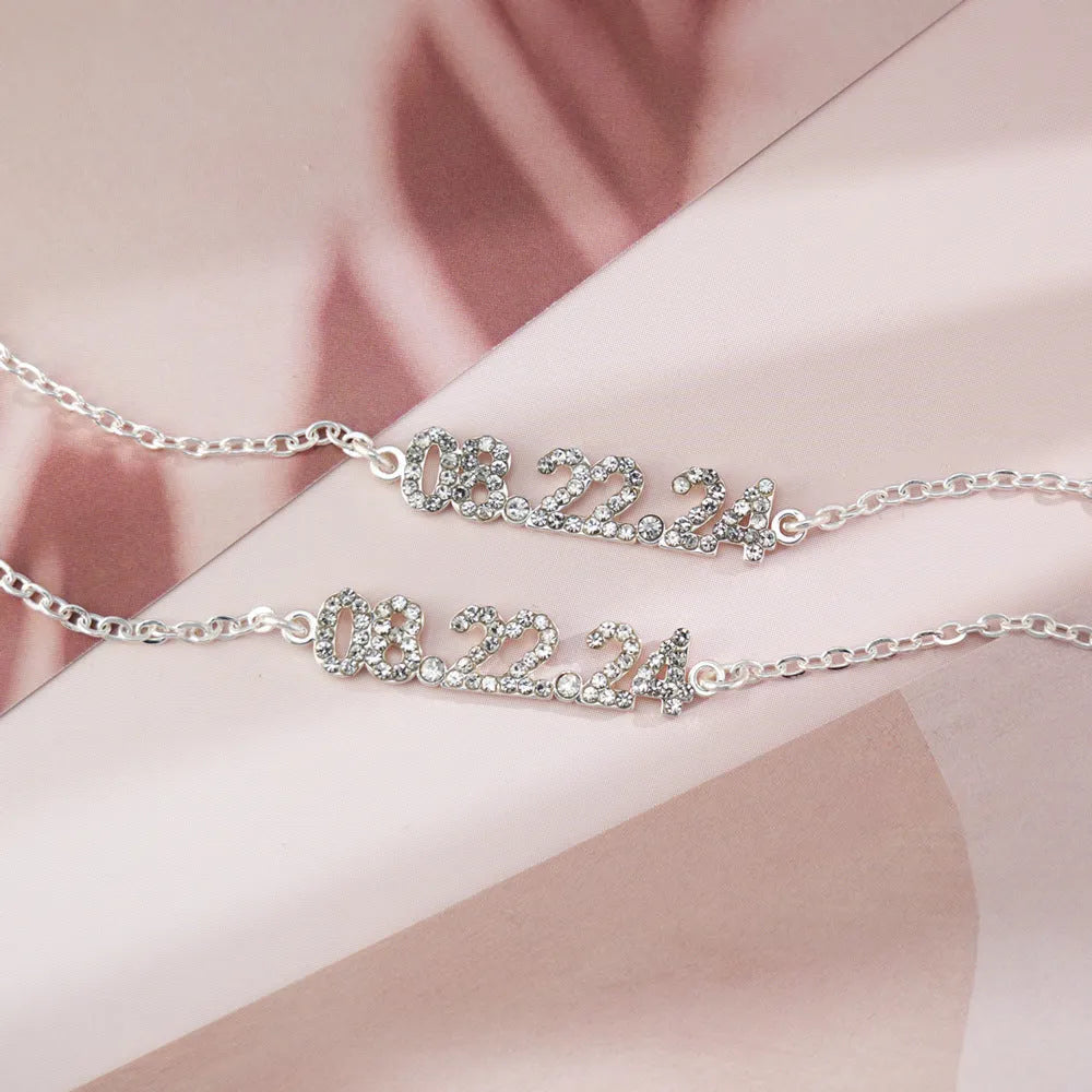 Stainless steel digital bracelet or necklace with diamond-set numbers on display, shown in gold colour.