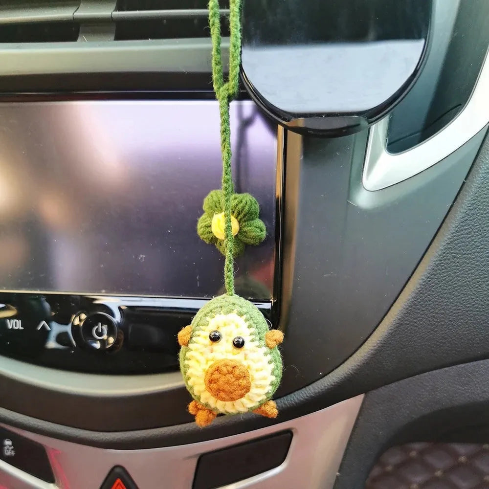 Handmade crocheted avocado-shaped rainbow flower car pendant hanging, shown in multiple colour options.