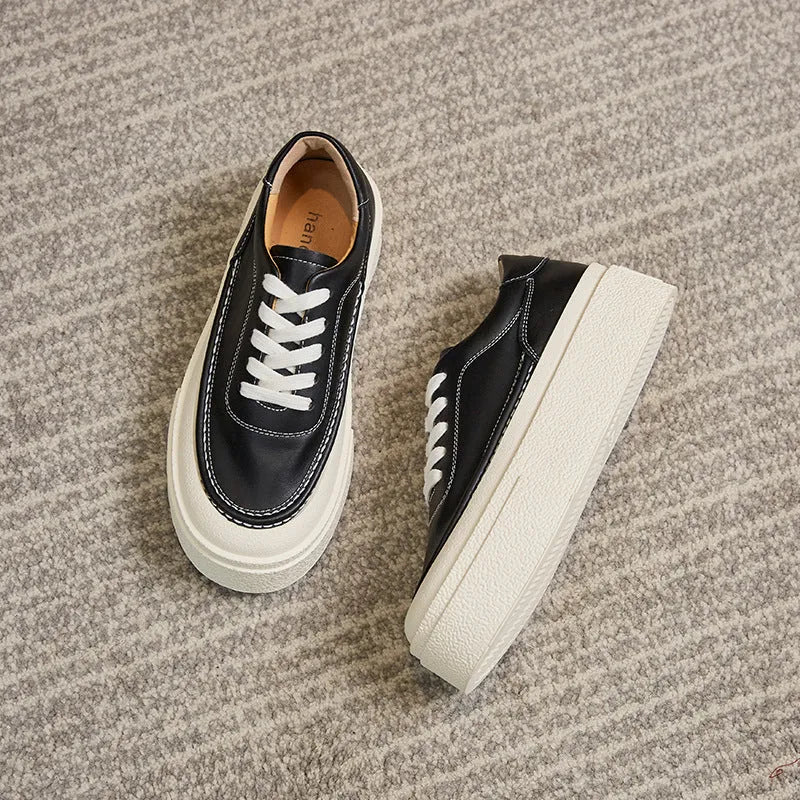 Women's black platform casual sports shoes with embossed leather upper and round toe.