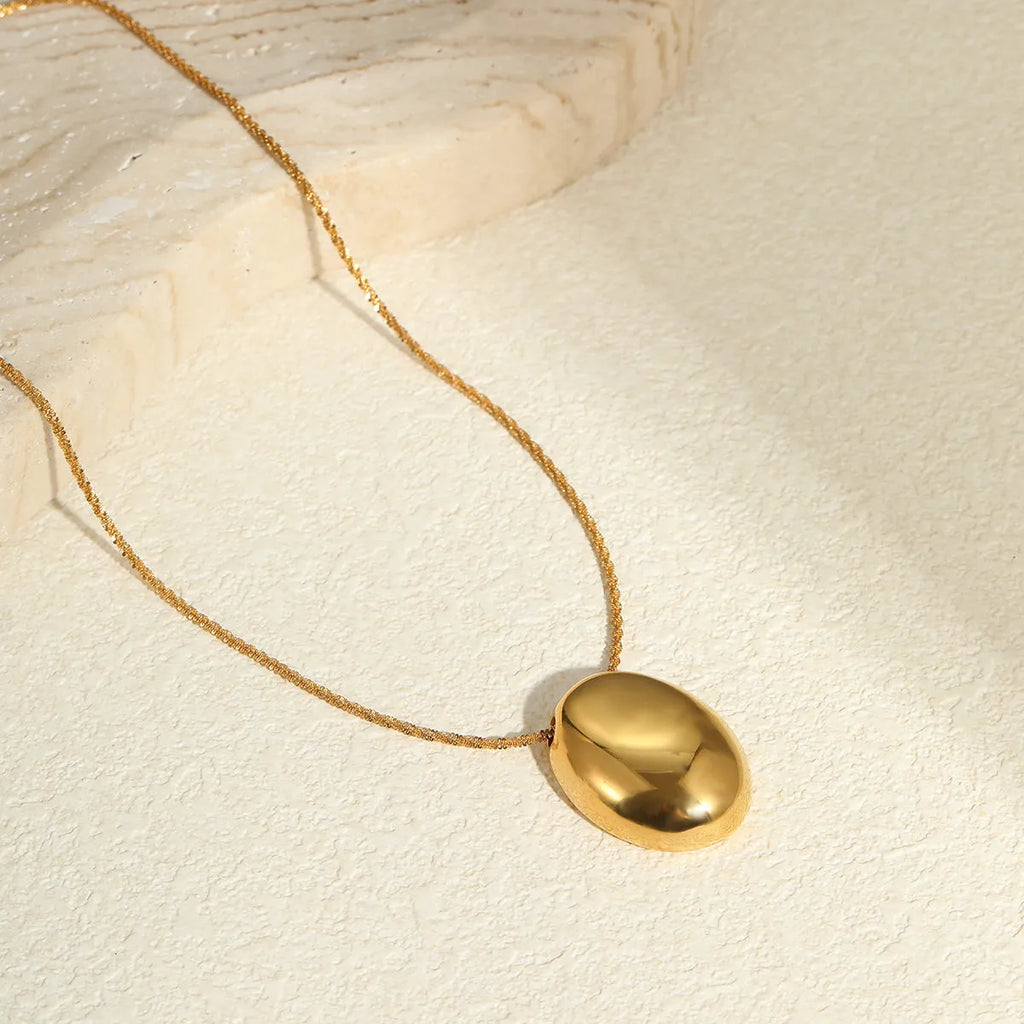 Gold-plated geometric pendant necklace with stainless steel chain on black background