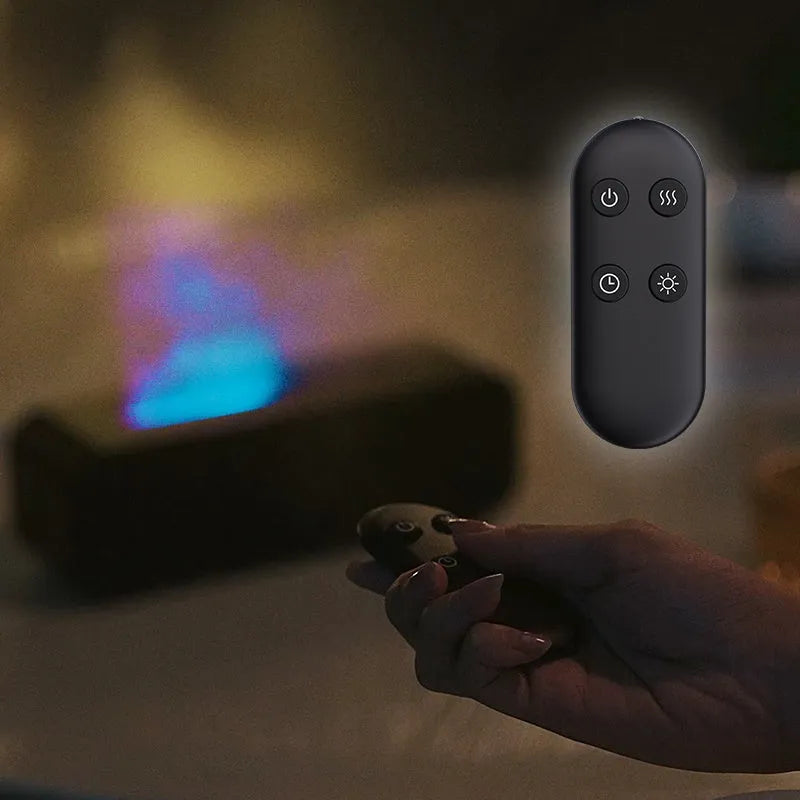 Black and white USB aroma diffuser with remote control on a desk, showing colour-changing LED lights.