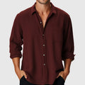 Man wearing a loose-fitting long sleeve beach shirt with a stand collar, available in various colours.