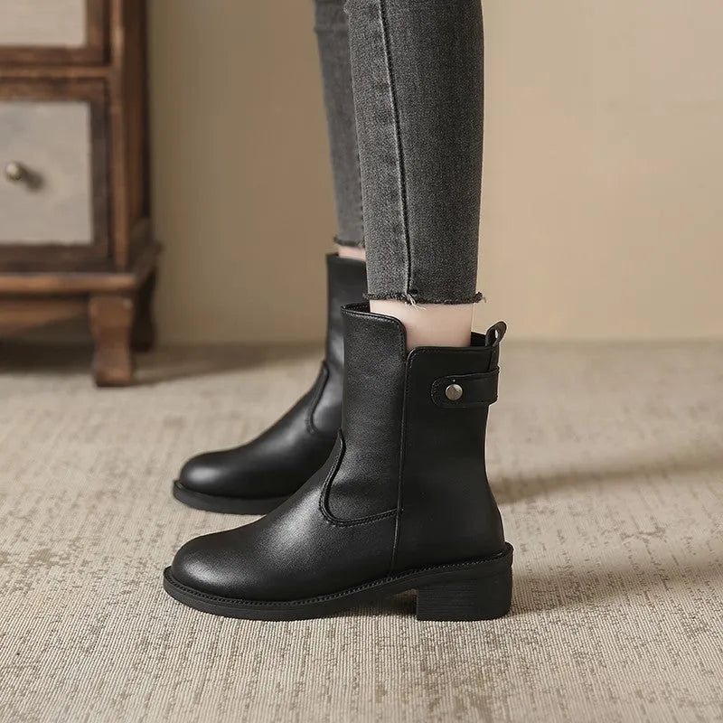 Black women's short ankle boots with a side zip, low heel, and round toe on a rubber sole.