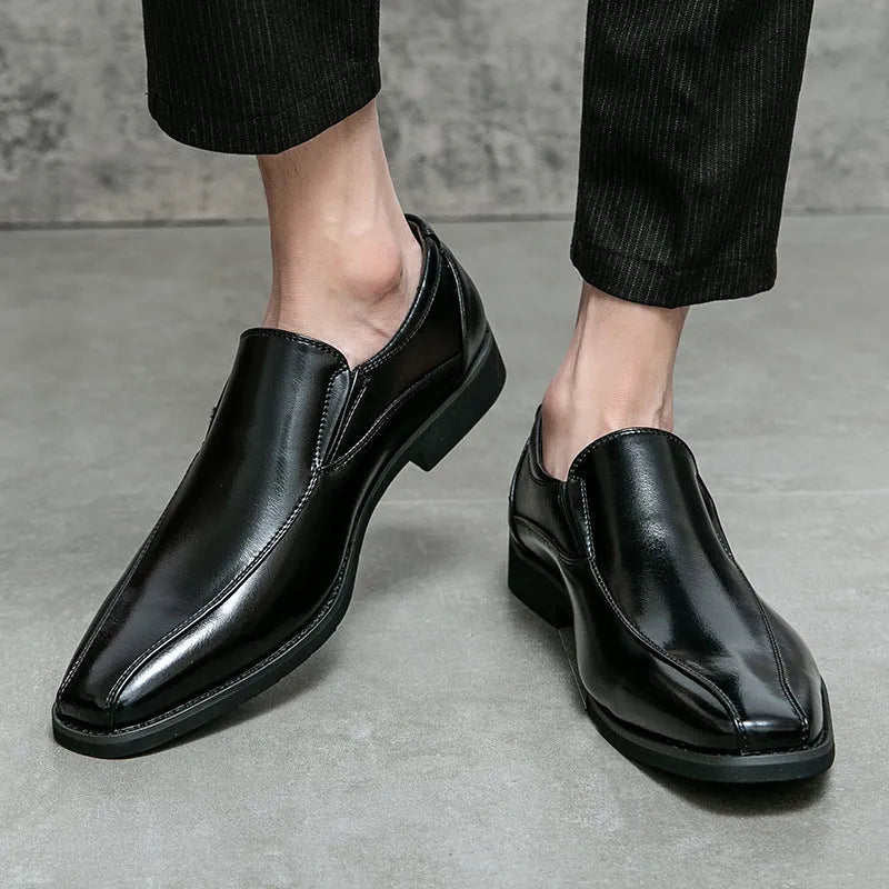 Men's black pointed casual shoes with a patent leather look and flat rubber sole.