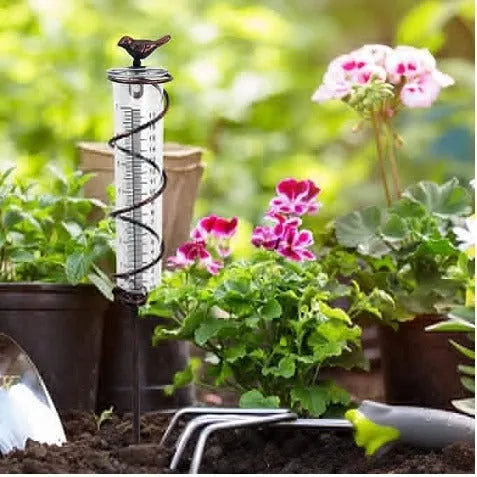 Cast iron and glass outdoor rain gauge with bird design and measurement scale for garden rainfall monitoring